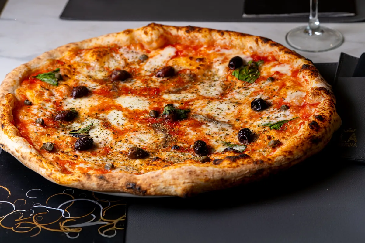Finished Neapolitan-style pizza with a deeply browned, risen rim